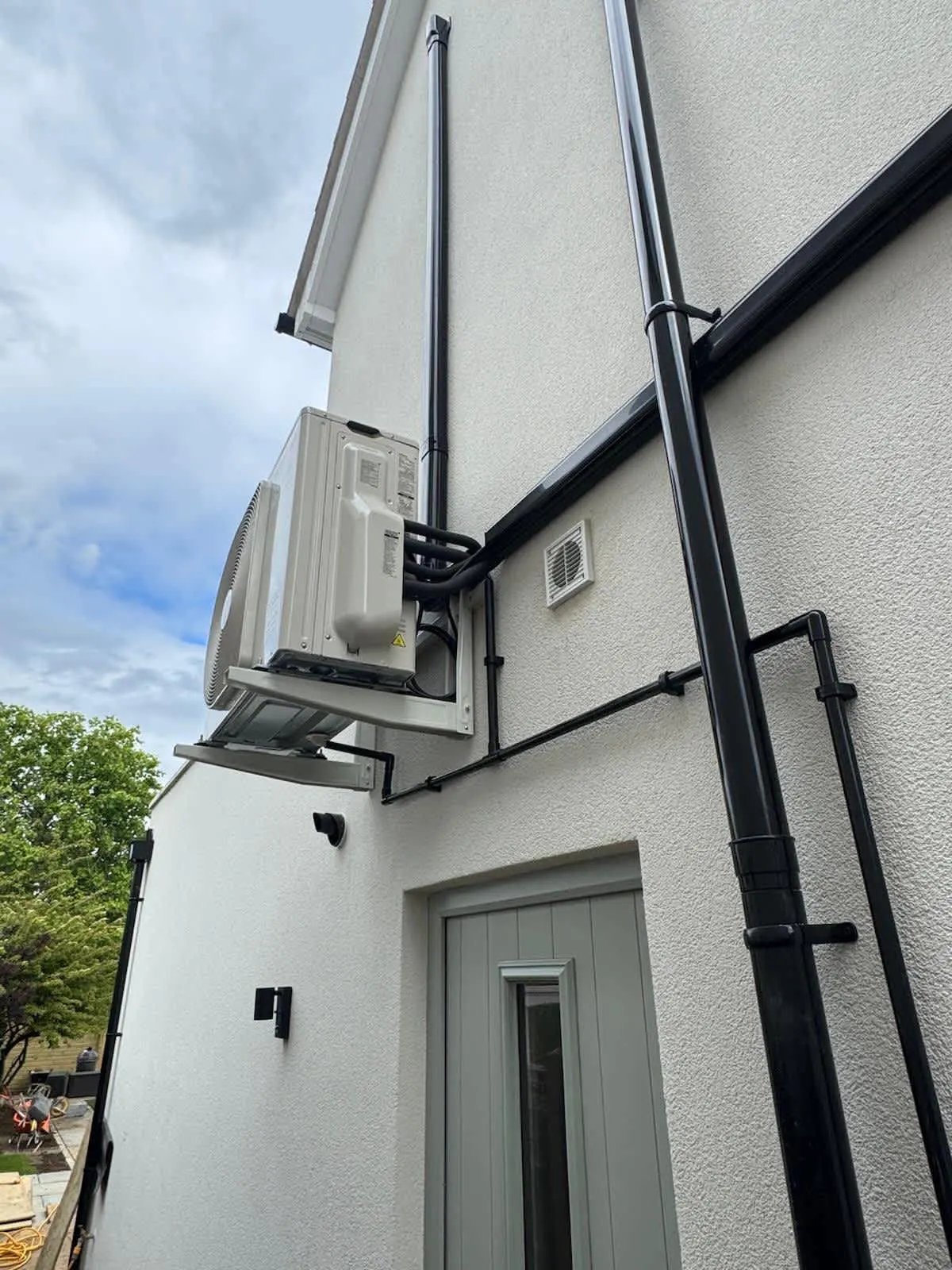 Outdoor unit and trunking neatly routed across a rendered wall to the outdoor condenser.